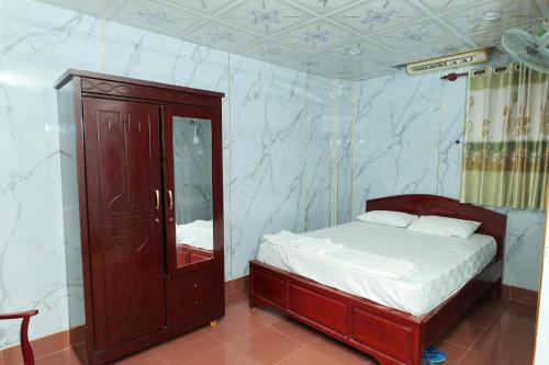 1 dormitorio con 1 cama y armario con espejo en Thanh Nhàn 1 Hotel Cà Mau - by BAYLUXURY, en Xóm Lơn