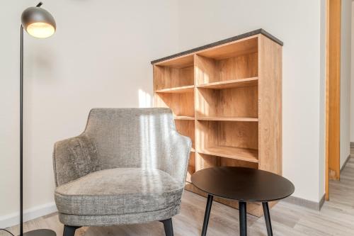 a chair and a table next to a book shelf at Hotel Esplanade Dortmund in Dortmund