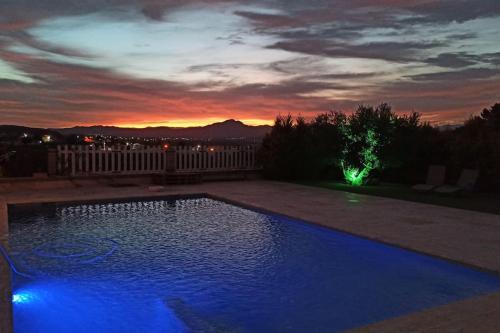 a pool with blue lights in a backyard at dusk at Casa rural Las Golondrinas in Huércal-Overa