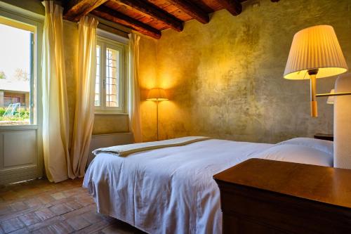 a bedroom with a white bed and a window at Relais Corte Guastalla Apartments in Sona