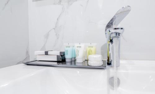 a bathroom shelf with products on it next to a sink at The Grandville Manor Hotel in Kampala