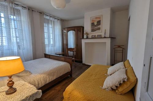 - une chambre avec un lit, une lampe et une cheminée dans l'établissement Pyrenean charm - Veranda - outdoor courtyard, à Bagnères-de-Bigorre