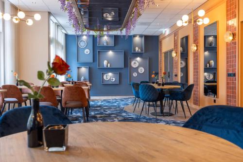 a dining room with blue walls and tables and chairs at Fletcher Boutique Hotel De Mallejan in Vierhouten