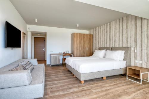 a hotel room with a bed and a couch at Utopia Blu Hotel in Tigaki