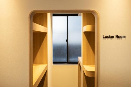 a mirror in a room with a window at Hotel Paul House in Tokyo