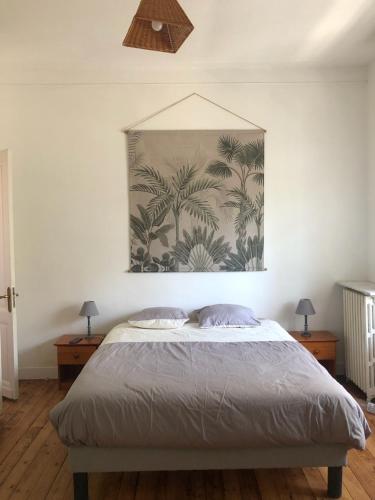 une chambre avec un lit avec un tableau sur le mur dans l'établissement La loggia, à La Tremblade