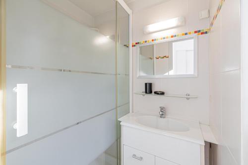 une salle de bain blanche avec un lavabo et un miroir dans l'établissement 16 FORV - Apartment for 4 people City center - 300m Palais, à Cannes