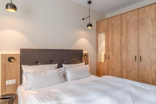a bedroom with a large white bed with wooden cabinets at Hotel Esplanade Dortmund in Dortmund