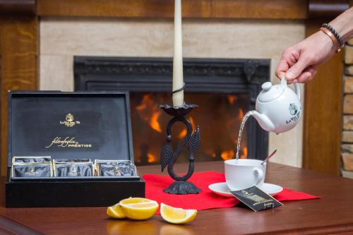 a person pouring coffee into a cup on a table at Boutique Hotel Budzak in Ždiar