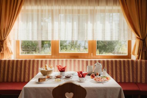 een tafel met eten voor een raam bij Pension Torr in San Martino in Badia