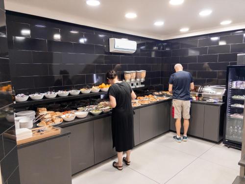 two people are preparing food in a kitchen at B&B Sweet Sleep in Naples