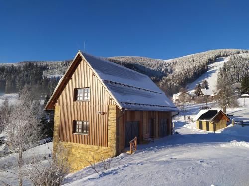 a small wooden cabin in the snow with snow at Chalupy ABJ a Apartmány ve Stodole ABJ Kraličák in Hynčice pod Sušinou