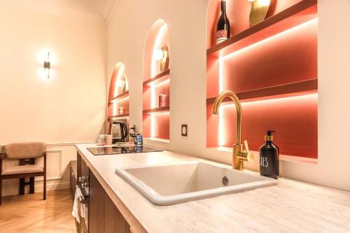 - une cuisine avec un évier et un comptoir avec des bouteilles de vin dans l'établissement Luxe Rouvet I Netflix I Calme, à Paris
