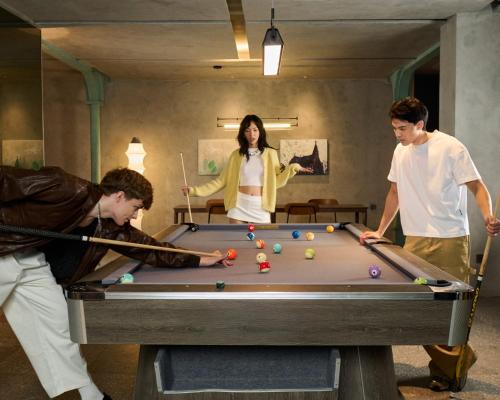 a group of three people playing a game of pool at M Village Hotel Da Nang Centre - Free Laundry and Kitchen in Da Nang