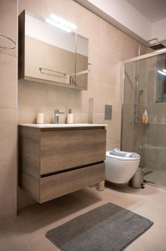 a bathroom with a sink and a toilet and a shower at LYAN Cozy Apartment by HOME SH in Nafplio