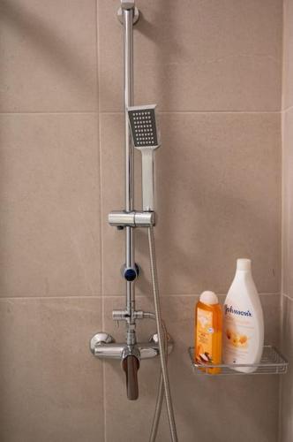 a shower with a hair dryer and a bottle of soap at LYAN Cozy Apartment by HOME SH in Nafplio