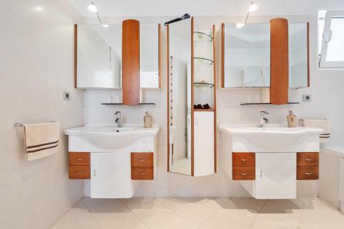 une salle de bain avec deux lavabos et deux miroirs dans l'établissement Villa Funchal bay view, à Funchal