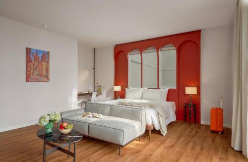 a bedroom with a bed and a couch at M Village Hotel Da Nang Centre - Free Laundry and Kitchen in Da Nang