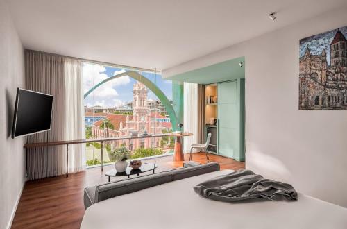 a bedroom with a bed and a large window at M Village Hotel Da Nang Centre - Free Laundry and Kitchen in Da Nang