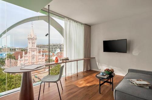 a living room with a table and a large window at M Village Hotel Da Nang Centre - Free Laundry and Kitchen in Da Nang