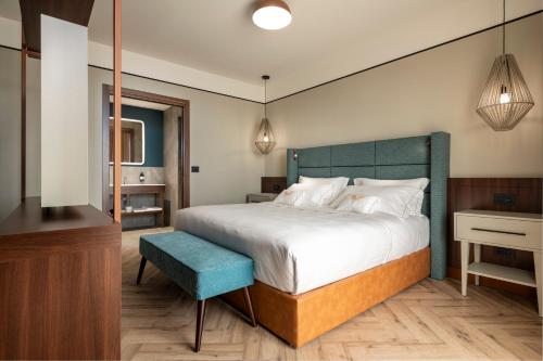 a bedroom with a large bed and a blue stool at Visionair Suites & SPA-Room Only e Honesty Bar in Senigallia