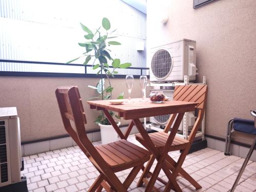 a wooden table and two chairs on a balcony at EIDOUYADO鶴見橋QB-one 10min難波 3min全生活便利 in Osaka