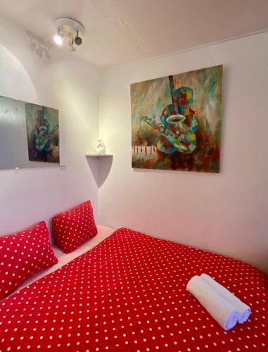 - un lit rouge dans une chambre avec 2 peintures dans l'établissement Studio chic Paris Tour Eiffel Near Eiffel tower 7th floor, à Paris