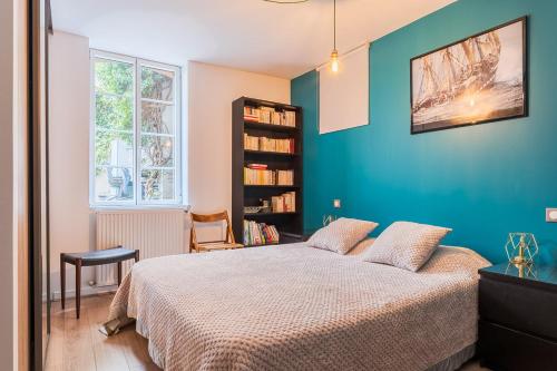 une chambre avec un lit et un mur bleu dans l'établissement Apt T5 rénové avec bureau jardin et parking en centre ville, à Toulouse