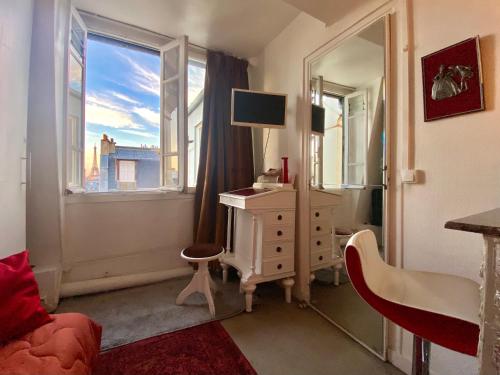 a room with a desk and a window with a television at Studio chic Paris Tour Eiffel Near Eiffel tower 7th floor in Paris