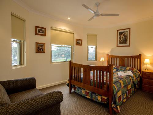 a bedroom with a crib and a chair at Royal Hotel in Springwood