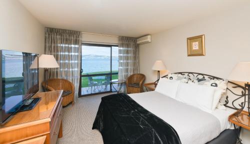 a hotel room with a bed and a view of the ocean at Millennium Hotel & Resort Manuels Taupo in Taupo