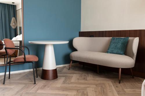 a living room with a chair and a table at Visionair Suites & SPA-Room Only e Honesty Bar in Senigallia