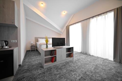 a bedroom with a bed and a desk with a television at Stonehenge Hotel & Restaurant in Tsaghkadzor