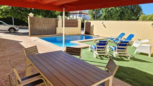 patio ze stołem i krzesłami oraz basenem w obiekcie Casa de la Jara 10 w mieście Sanlúcar de Barrameda