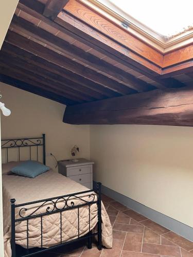 a bedroom with a bed and a wooden ceiling at Agriturismo Musignano in Cerreto Guidi