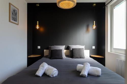 a bedroom with a bed with two towels on it at La Maison du Parc in Digoin