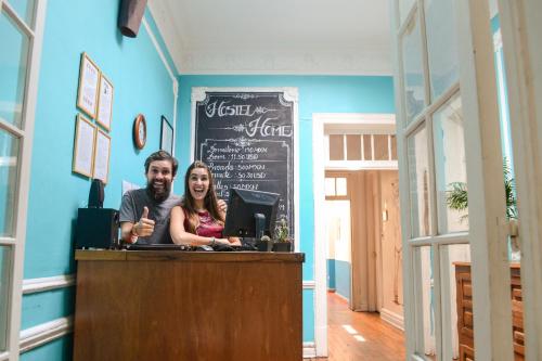 un hombre y una mujer sentados en un mostrador en un bar en Hostel Home, en Ciudad de México