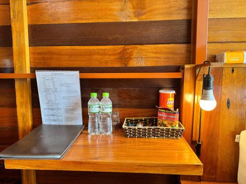 a wooden table with a laptop and bottles of water at JoyStay in Cat Ba