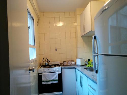 Una pequeña cocina con estufa y refrigerador. en Apartamento Edificio Crucero, en Buenos Aires