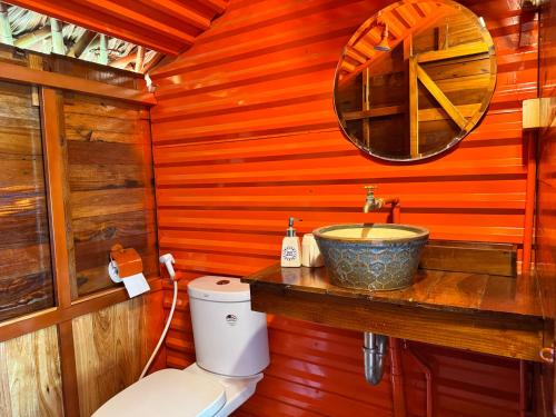 a wooden bathroom with a sink and a toilet at JoyStay in Cat Ba