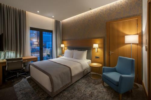 a bedroom with a bed and a desk and a blue chair at Holiday Inn Istanbul - Tuzla Bay by IHG in Istanbul