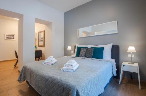 a bedroom with a bed with towels on it at D&A Amphitheatre Apartments with free parking in Pula