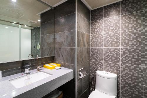 a bathroom with a toilet and a sink and a mirror at The Cloud Hotel in Taichung