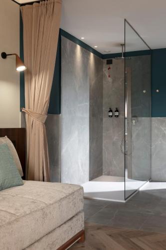a bedroom with a shower with a glass door at Visionair Suites & SPA-Room Only e Honesty Bar in Senigallia