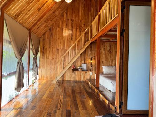 a bedroom with a bed in a wooden house at JoyStay in Cat Ba