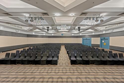 an empty auditorium with black chairs in a room at Crowne Plaza Surfers Paradise by IHG in Gold Coast