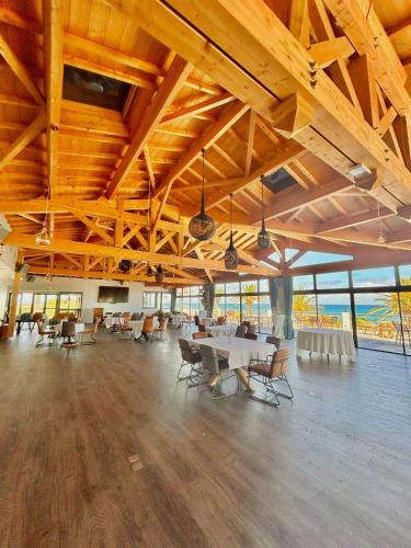 une grande pièce avec des tables, des chaises et des fenêtres dans l'établissement Résidence San Pellegrino, à Folelli