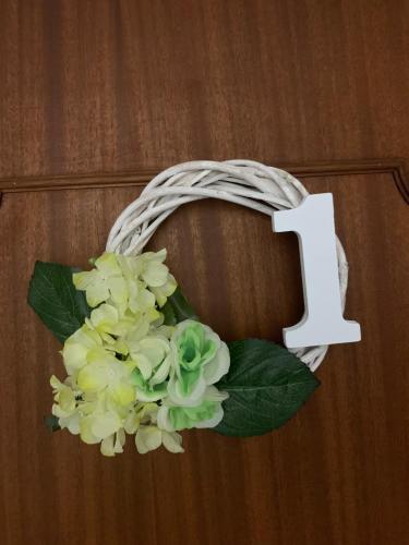 a wreath with flowers and a number one on a door at B&B Sole e Luna in Ponte Galeria