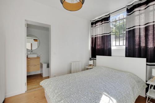 a bedroom with a bed and a sink and a window at Centre Vincennes - Logement cosy in Vincennes