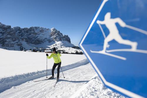 a person on skis in the snow with a shadow at Hotel Waldruhe in Gsies